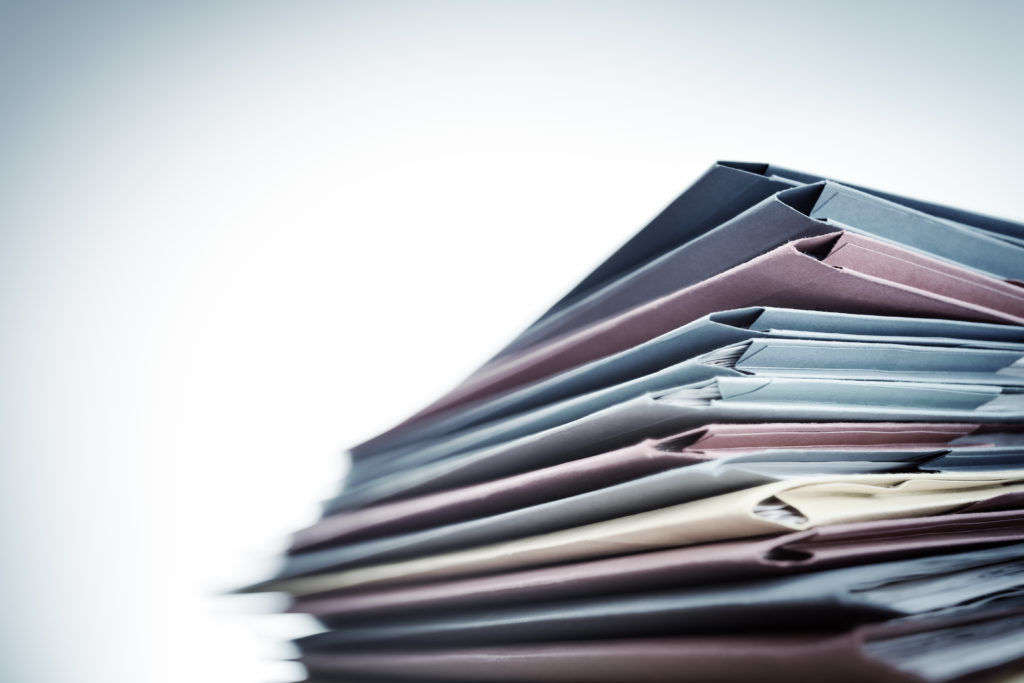 Stack of business documents and folders symbolizing telecom tax paperwork. 